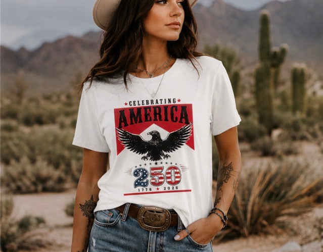 Woman wearing a t-shirt with an eagle graphic and text in a desert setting