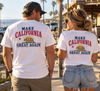 A man and a woman standing on a sunny boardwalk wearing matching white graphic t-shirts with the text 'MAKE CALIFORNIA GREAT AGAIN' and a California grizzly bear design on the back.