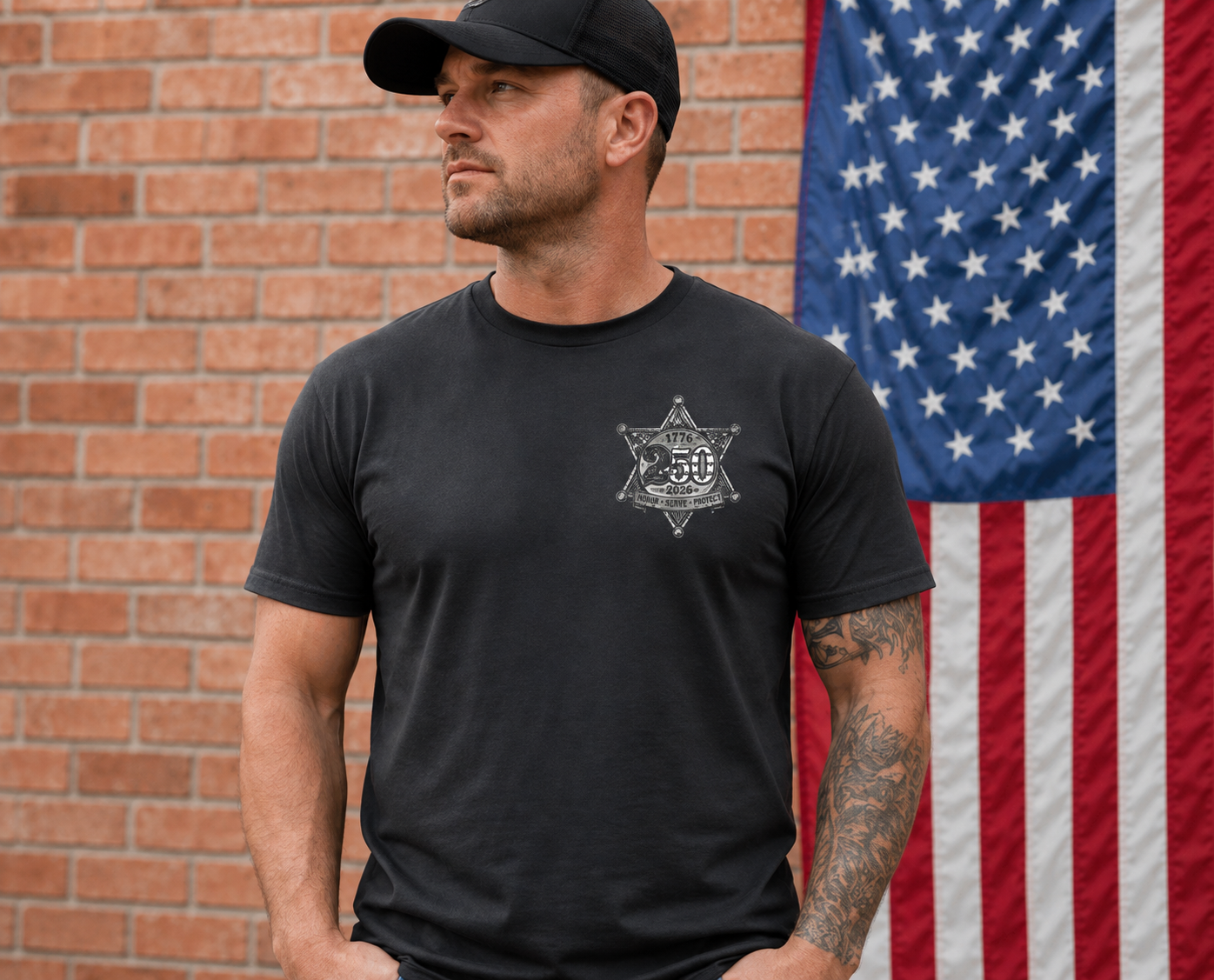 Man wearing a black t-shirt with a SHERIIFF Logo in front of an American flag.