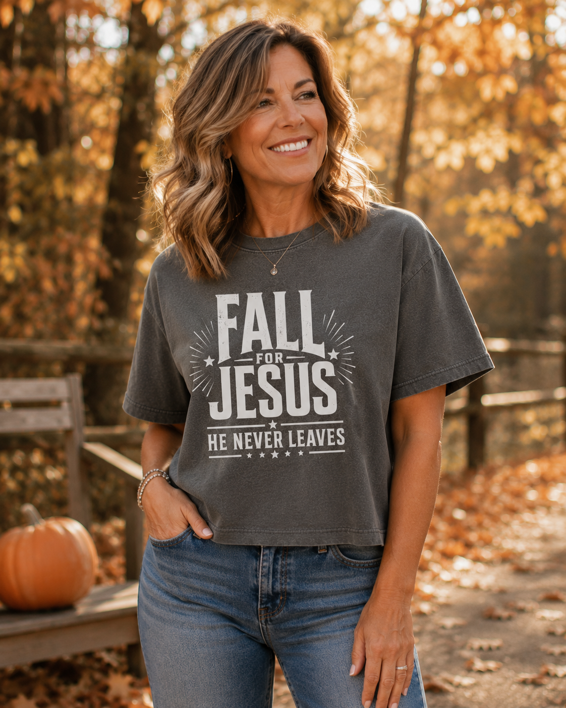 Woman in park setting with a pumpkin on a bench wearing Fall for Jesus He Never Leaves women's boxy tee, comfort colors garment dyed shirt