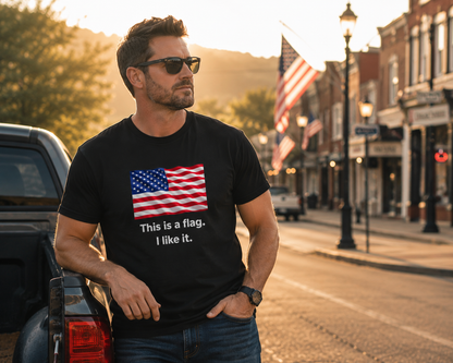 A man wearing a black graphic t-shirt with an American flag print and the text 'This is a flag. I like it.