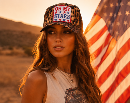 Woman wearing a cap with 'OH MY STARS' text in front of an American flag.