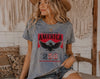 Woman wearing a t-shirt with 'Celebrating America 250' design in a casual setting.