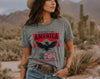 Woman wearing a gray t-shirt with 'Celebrating America 250' design in a desert setting