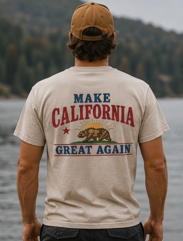 Person wearing a t-shirt with 'Make California Great Again' text and bear graphic, standing by a body of water.