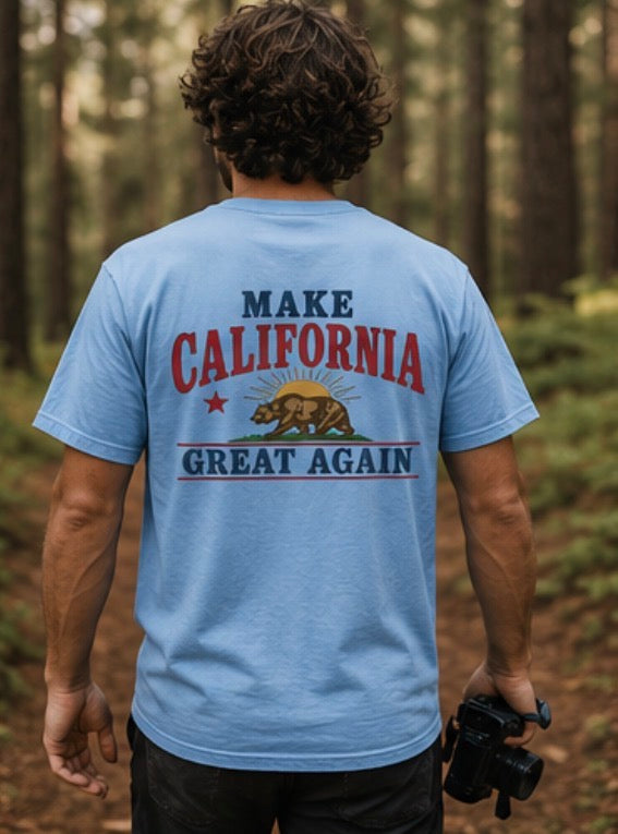 Person wearing a blue t-shirt with 'Make California Great Again' text in a forest setting