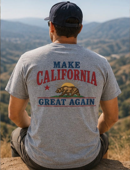 Person wearing a t-shirt with 'Make California Great Again' text and bear graphic, sitting on a hilltop.
