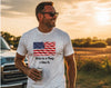 A man wearing a white graphic t-shirt with a printed American flag and the text 'This is a flag. I like it.