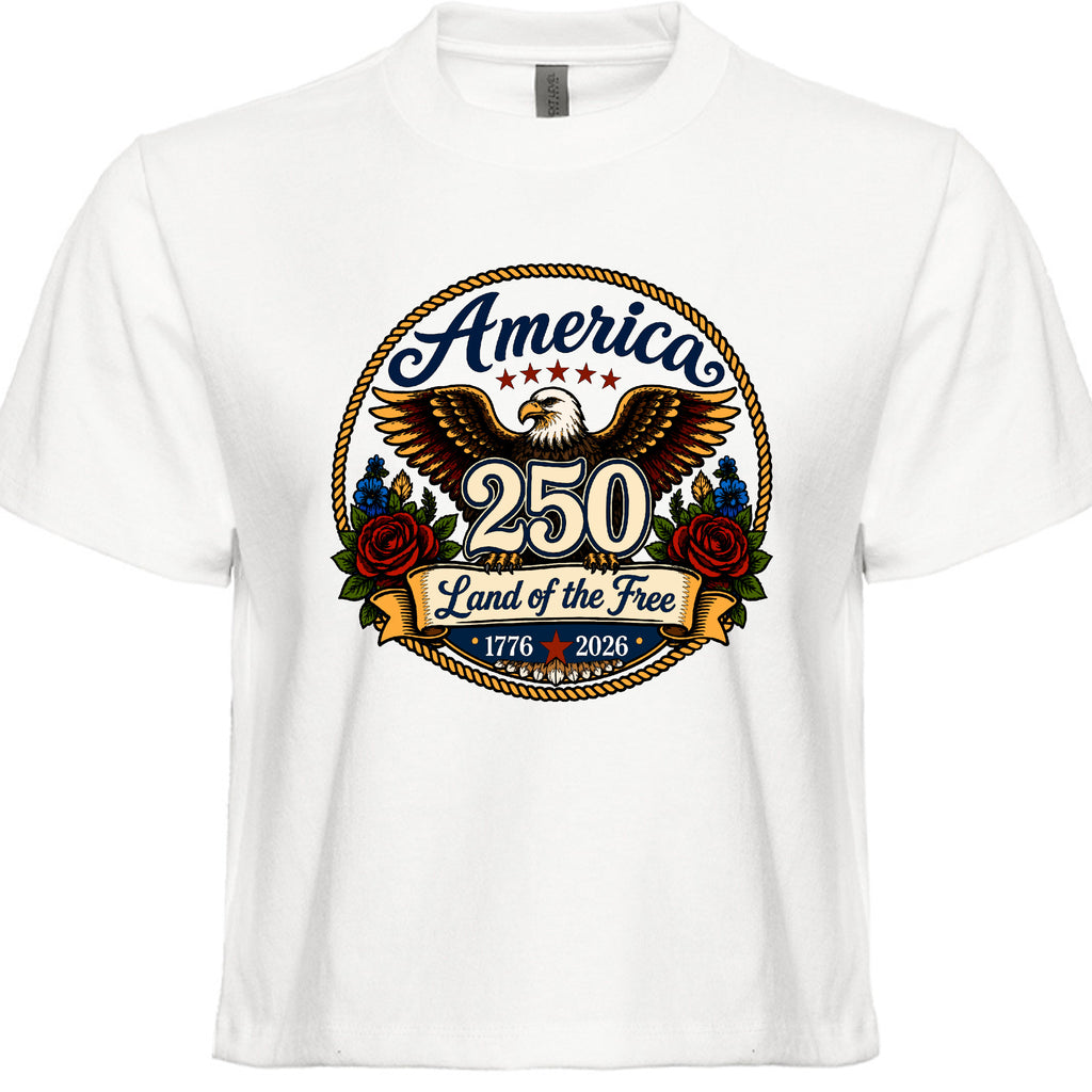 Women's white patriotic tee with vintage tattoo style circular graphic featuring golden eagle red roses gold rope border and America 250 Land of the Free 1776 to 2026 design
