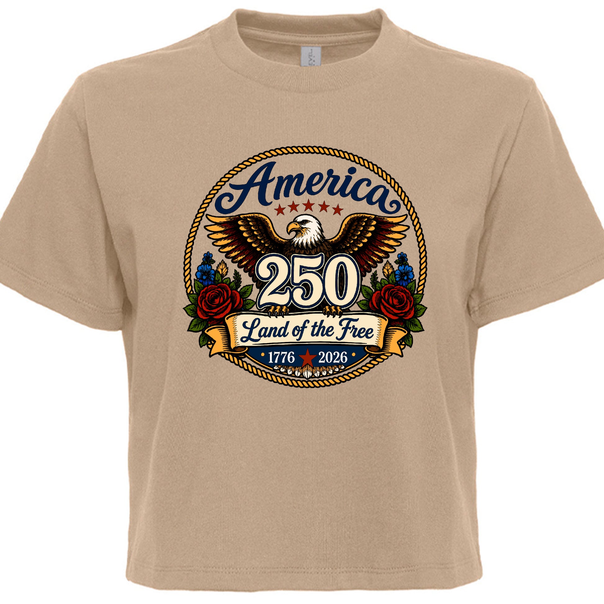 Women's tan patriotic tee with vintage tattoo style circular graphic featuring golden eagle red roses gold rope border and America 250 Land of the Free 1776 to 2026 design
