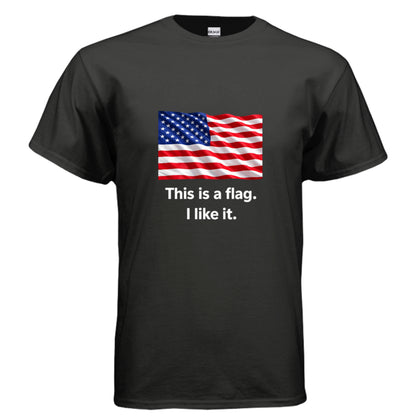 A black short-sleeve crewneck t-shirt featuring a graphic of the American flag with the text 'This is a flag. I like it.